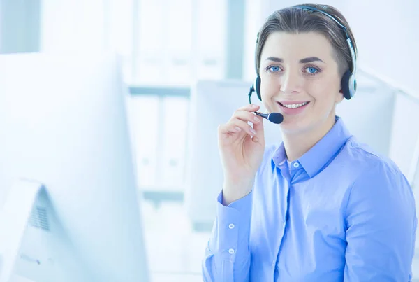 Ernstige mooie jonge vrouw die werkt als support telefoon operator met headset in het kantoor — Stockfoto