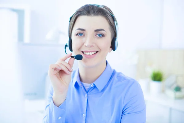 Ernstige mooie jonge vrouw die werkt als support telefoon operator met headset in het kantoor — Stockfoto