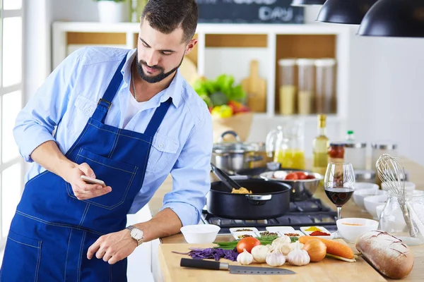 Мужчина держит бумажный пакет, полный продуктов на кухонном фоне. Концепция здорового питания — стоковое фото