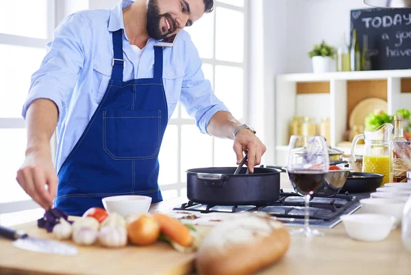 家のキッチンでおいしいと健康食品を準備する男 — ストック写真