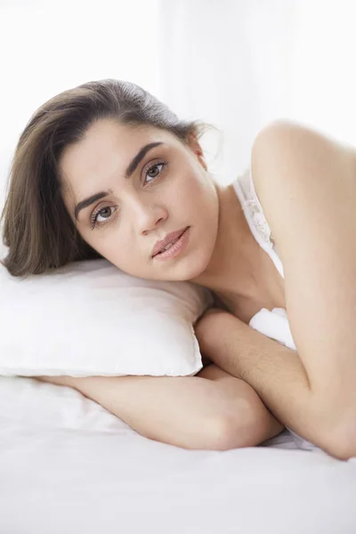 Pretty woman lying down on her bed at home