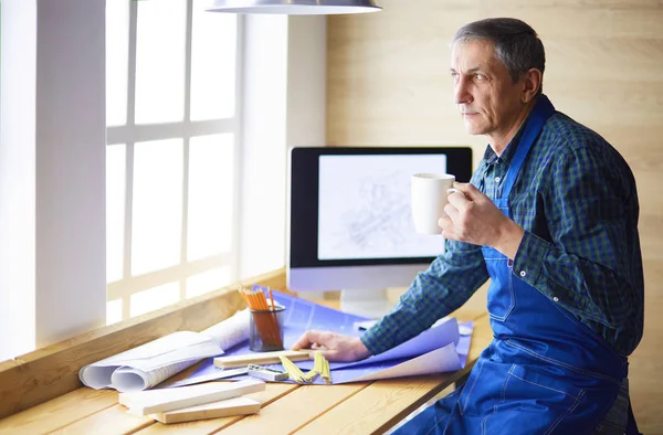 Arquitecto trabajando en mesa de dibujo en la oficina —  Fotos de Stock