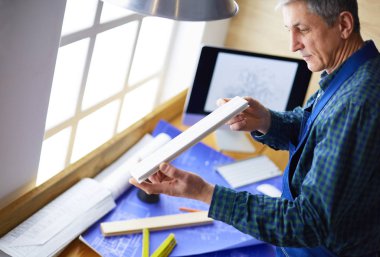 Ofisteki çizim masasında çalışan mimar