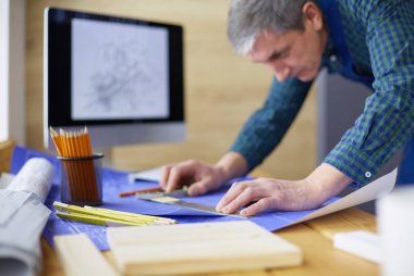 Ofisteki çizim masasında çalışan mimar