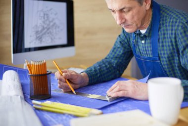 Ofisteki çizim masasında çalışan mimar