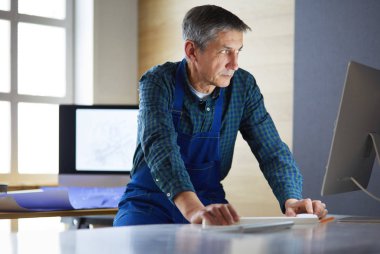 Ofisteki çizim masasında çalışan mimar