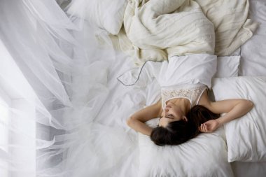 Güzel bir kadın yatağında uzanıyor.