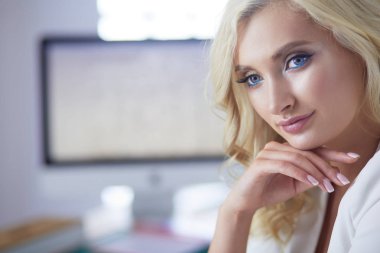 Güzel genç kadın portresi, ofiste oturuyor..