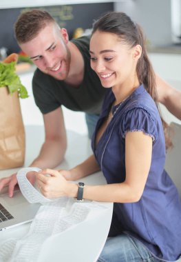 Çift evde mutfak içinde laptop ile onların fatura ödeme