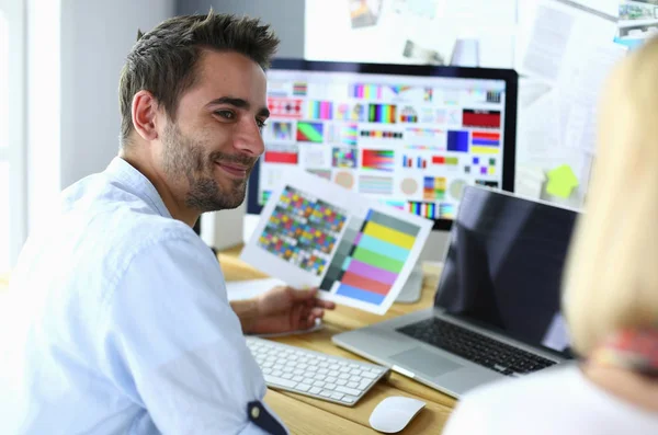 Porträt eines jungen Designers, der im Grafikstudio vor Laptop und Computer sitzt, während er online arbeitet. — Stockfoto