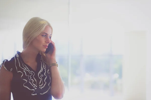 A beautiful blond business woman is talking on the phone. — Stock Photo, Image