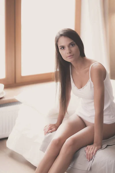 Wanita muda duduk di tempat tidur dengan secangkir susu — Stok Foto