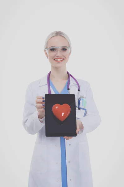 Médica jovem segurando um coração vermelho, isolado em fundo branco. Mulher médica — Fotografia de Stock