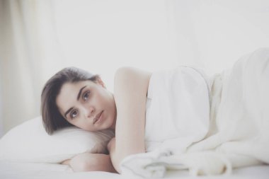 Güzel bir kadın yatağında uzanıyor.