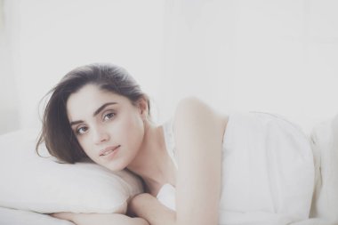 Güzel bir kadın yatağında uzanıyor.