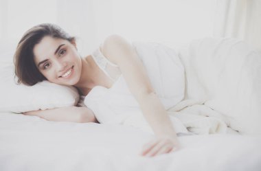 Güzel bir kadın yatağında uzanıyor.