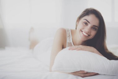 Güzel bir kadın yatağında uzanıyor.