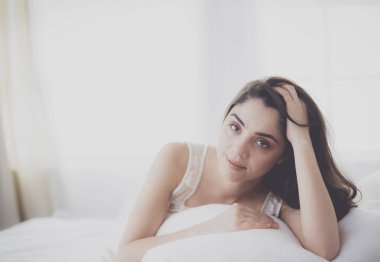 Güzel bir kadın yatağında uzanıyor.