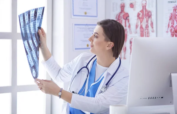 Porträt eines im Büro sitzenden Arztes mit Röntgenbild, der am Computer arbeitet — Stockfoto