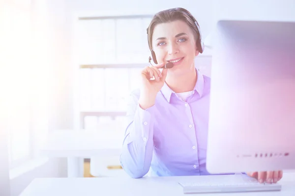 Grave bella giovane donna che lavora come operatore telefonico di supporto con auricolare in ufficio — Foto Stock