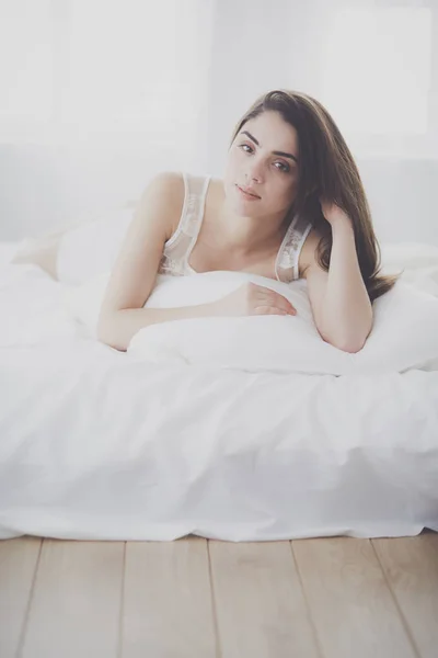 Csinos nő fekszik az ágyán otthon. — Stock Fotó