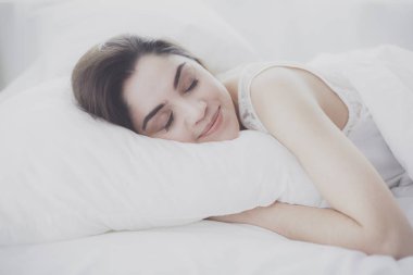 Güzel bir kadın yatağında uzanıyor.