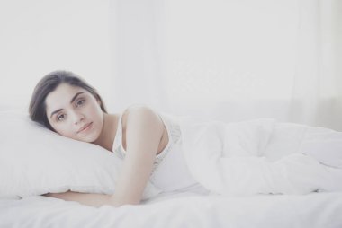 Güzel bir kadın yatağında uzanıyor.