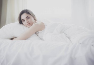 Güzel bir kadın yatağında uzanıyor.