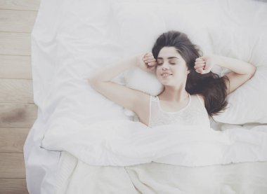 Güzel bir kadın yatağında uzanıyor.