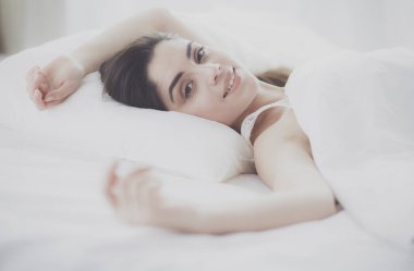 Güzel bir kadın yatağında uzanıyor.