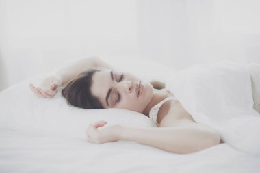 Güzel bir kadın yatağında uzanıyor.