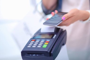 Müşteri ile smartphone Nfc teknolojisi kullanılarak dükkanda ödüyor. NFC teknolojisi. Müşteri ödeme