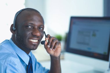 Kulaklıklı Afro-Amerikan işadamı laptopuyla çalışıyor.