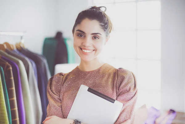 Mooie jonge stylist bij rek met hangers — Stockfoto