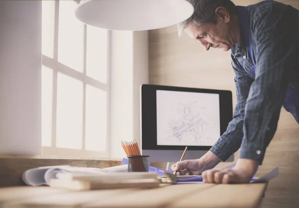 Arquitecto trabajando en mesa de dibujo en la oficina —  Fotos de Stock