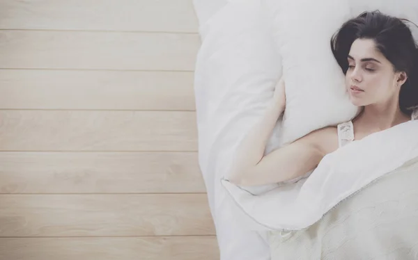 Pretty woman lying down on her bed at home — Stock Photo, Image