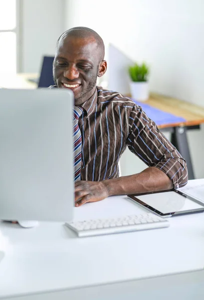 Beau Afro-Américain homme d'affaires en costume classique utilise un ordinateur portable et souriant tout en travaillant au bureau — Photo