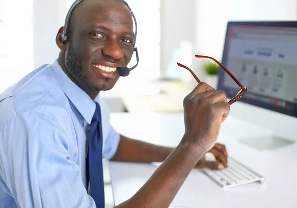 Homme d'affaires afro-américain sur casque de travail sur son ordinateur portable — Photo