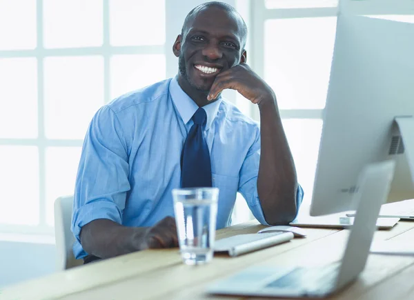 Afrikansk amerikansk affärsman på headset arbetar på sin bärbara dator — Stockfoto