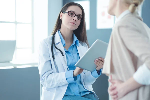 Médico e paciente discutindo algo enquanto se senta na mesa. Conceito de medicina e cuidados de saúde — Fotografia de Stock