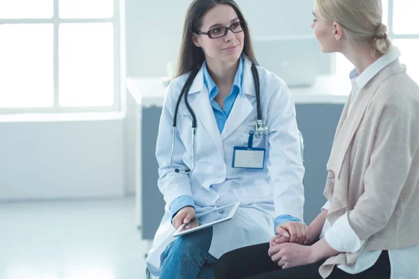 Doktorn och patienten diskuterar något när de sitter vid bordet. Medicin och hälsovård — Stockfoto