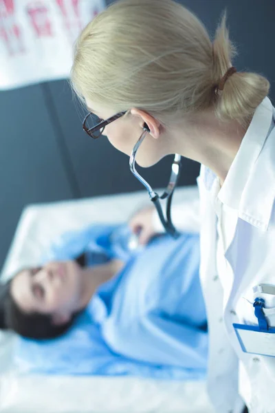 Arzt und Patient diskutieren etwas, während sie am Tisch sitzen. Medizin und Gesundheitskonzept — Stockfoto