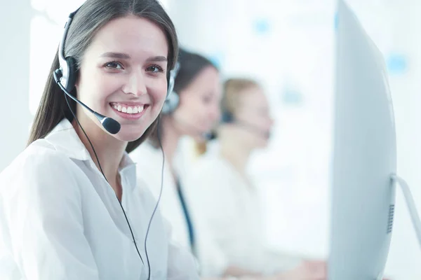 Mujer de negocios sonriente u operador de línea de ayuda con auriculares y computadora en la oficina — Foto de Stock