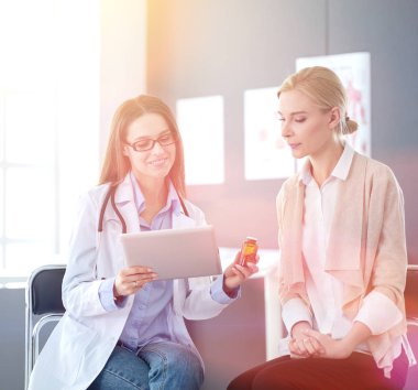 Doktor ve hasta masada otururken bir şey tartışıyorlar. İlaç ve sağlık hizmetleri kavramı