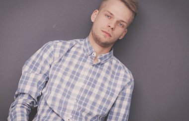 Ayakta, gri arka plan üzerinde izole delikanlı. Genç erkekler