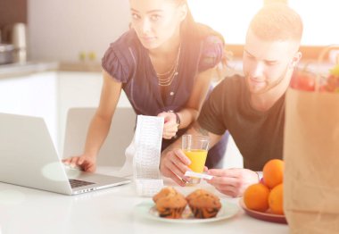 Çift evde mutfak içinde laptop ile onların fatura ödeme