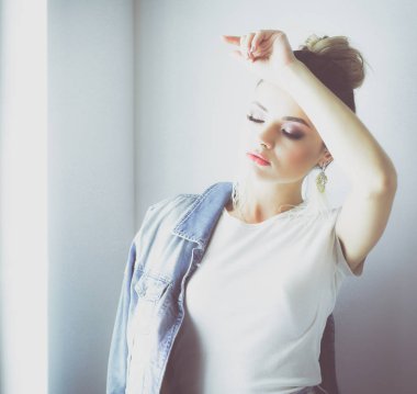 Pencerenin yanında duran güzel kadın portresi. Beyaz arka planda izole edilmiş.