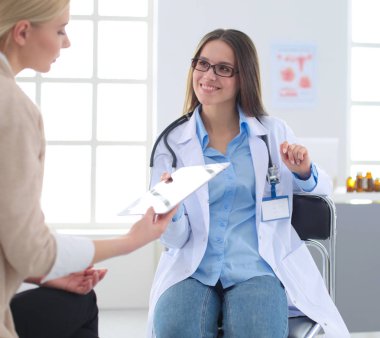 Doktor ve hasta masada otururken bir şey tartışıyorlar. İlaç ve sağlık hizmetleri kavramı