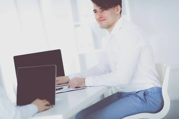 Heureux jeune homme travaille sur son ordinateur portable au bureau — Photo