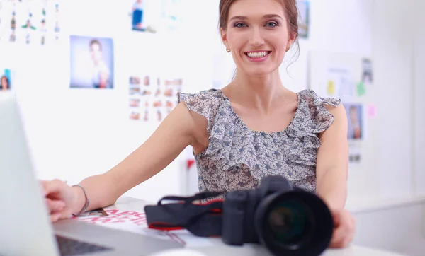 Portrét mladé krásné fotografky u stolu — Stock fotografie